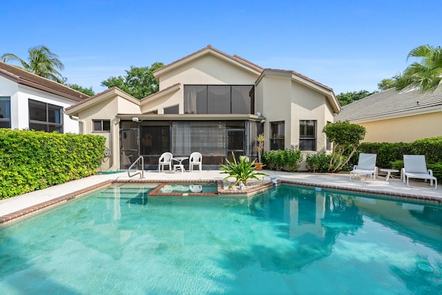 view of swimming pool featuring a patio area and a sunroom