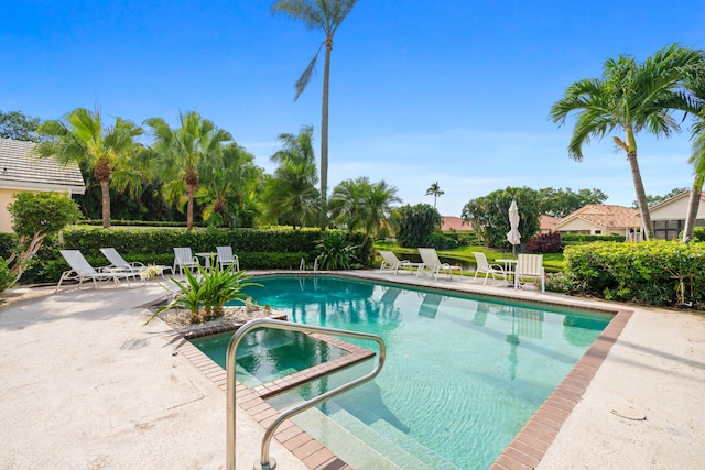 view of pool featuring a hot tub and a patio