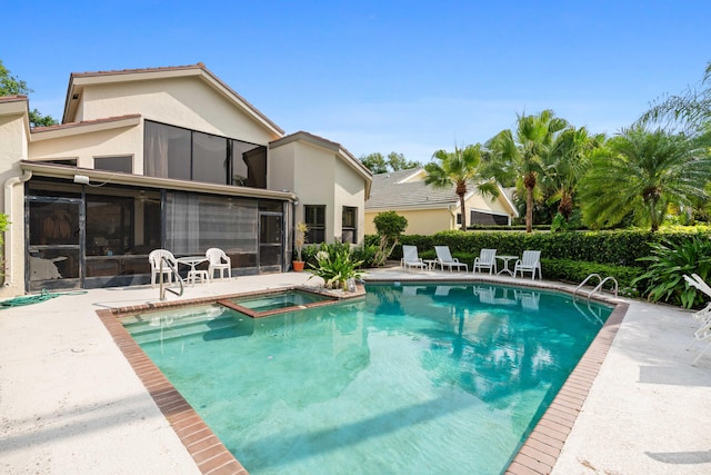 view of pool featuring an in ground hot tub, a patio, and a sunroom