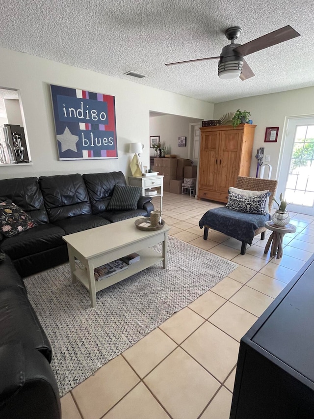 living room with tile patterned flooring, a textured ceiling, and ceiling fan