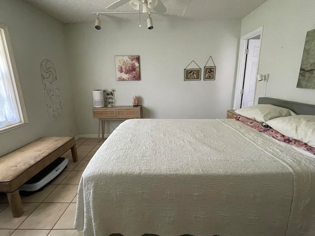 bedroom with light tile patterned floors, a textured ceiling, and ceiling fan