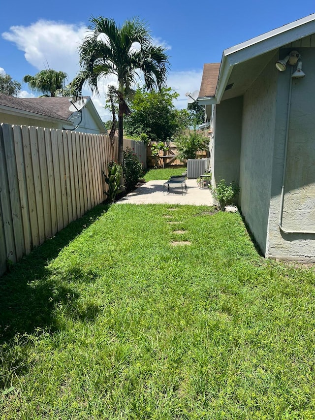 view of yard with cooling unit and a patio