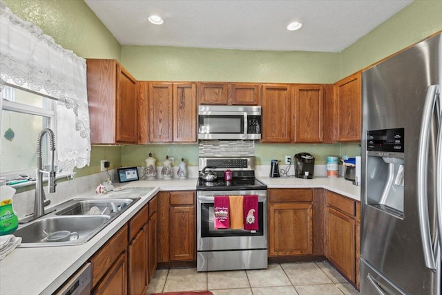 kitchen with sink, light tile patterned floors, and stainless steel appliances