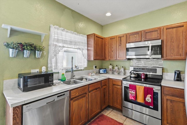 kitchen featuring light tile patterned floors, stainless steel appliances, and sink