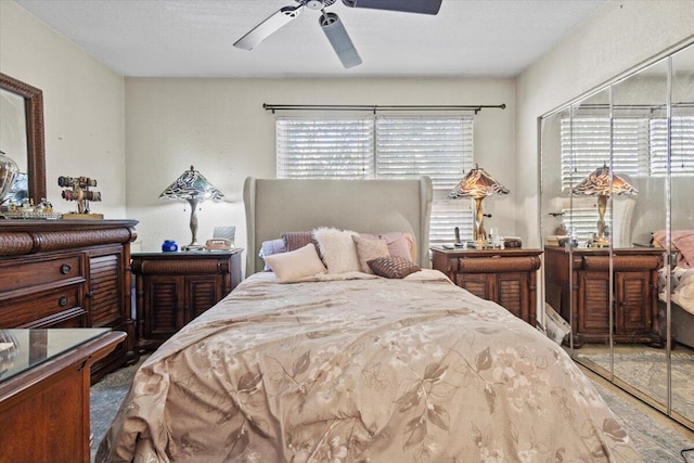 bedroom with multiple windows, ceiling fan, and a textured ceiling