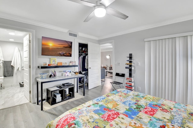 bedroom with light wood-type flooring, ensuite bathroom, ornamental molding, ceiling fan, and a closet