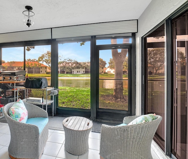 sunroom featuring a water view