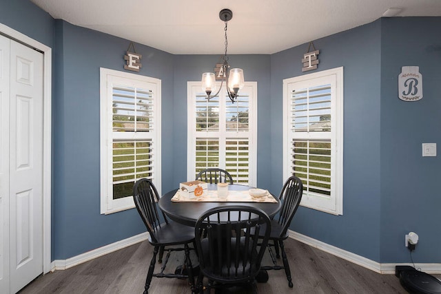 dining space featuring dark hardwood / wood-style flooring and a notable chandelier