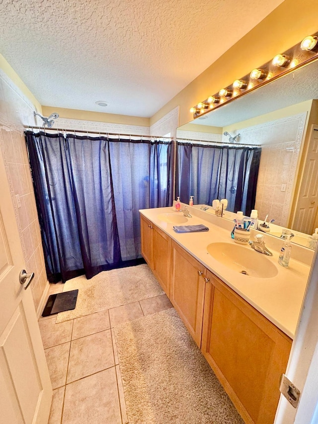 bathroom with walk in shower, vanity, tile patterned flooring, and a textured ceiling