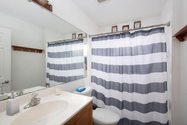 bathroom featuring vanity, toilet, and walk in shower