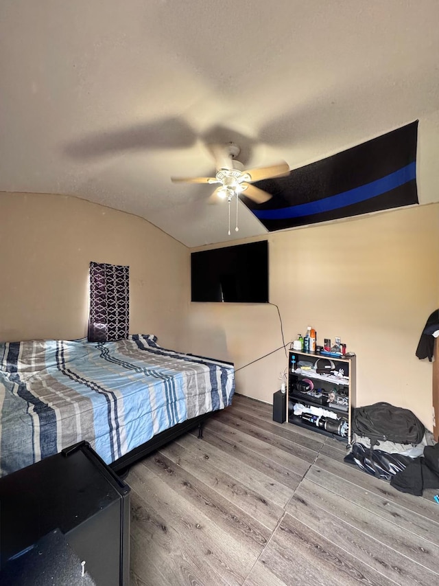 bedroom featuring hardwood / wood-style floors, vaulted ceiling, and ceiling fan