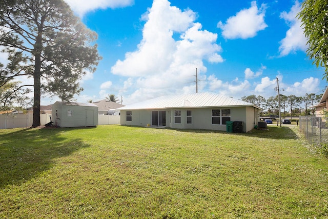 back of property with a yard and a shed