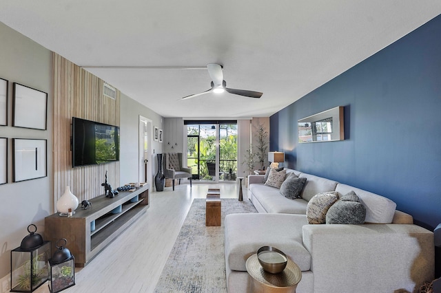 living room featuring ceiling fan and light wood-type flooring