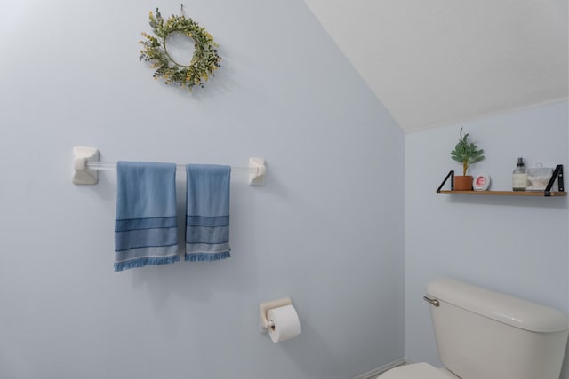 bathroom featuring vaulted ceiling and toilet