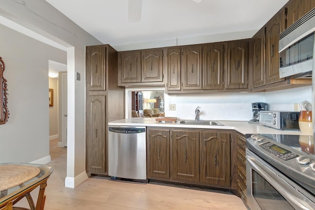 2300 NE 1st Ln Unit 307, Boynton Beach, FL 33435 - kitchen featuring stainless steel appliances, a sink, light countertops, dark brown cabinetry, and baseboards