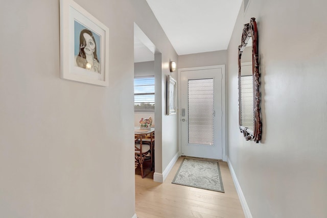 2300 NE 1st Ln Unit 307, Boynton Beach, FL 33435 - doorway to outside with healthy amount of natural light, light wood-style floors, and baseboards