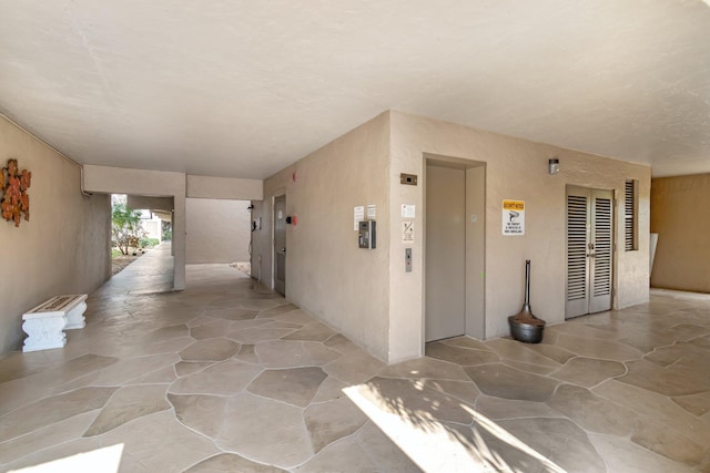 2300 NE 1st Ln Unit 307, Boynton Beach, FL 33435 - hall with elevator and stone floors