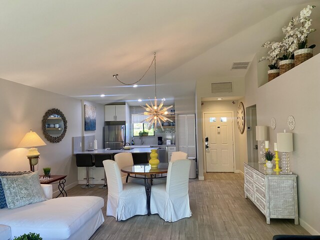 kitchen featuring sink, decorative backsplash, light hardwood / wood-style floors, white cabinetry, and stainless steel appliances