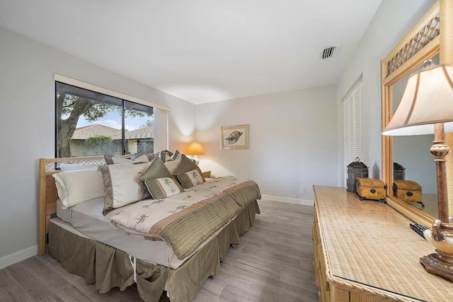 bedroom with dark hardwood / wood-style floors and a closet