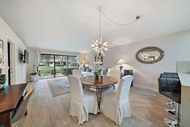 dining room with light wood-type flooring and a chandelier