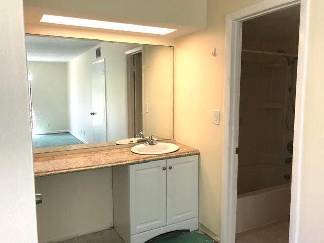 bathroom featuring vanity and  shower combination