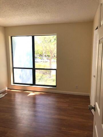 empty room featuring dark hardwood / wood-style floors and a textured ceiling