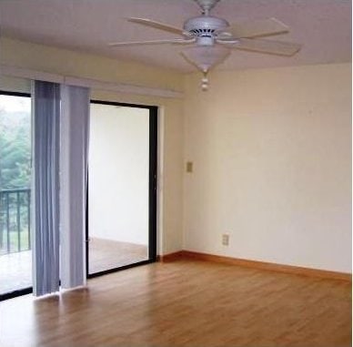 unfurnished room with hardwood / wood-style flooring, ceiling fan, and a healthy amount of sunlight