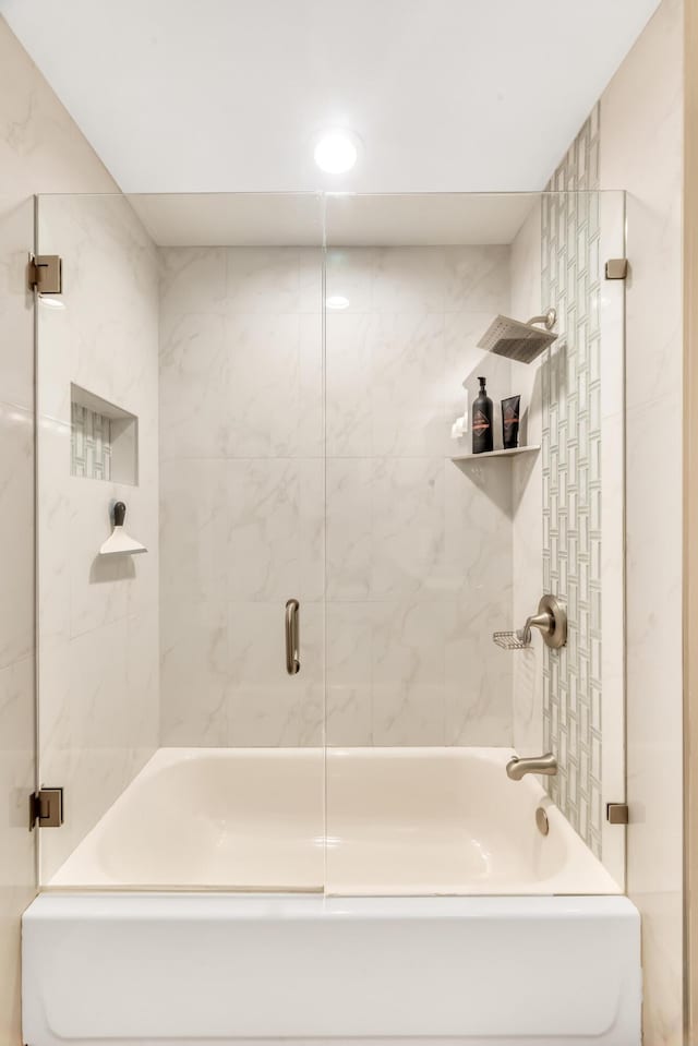 bathroom with bath / shower combo with glass door