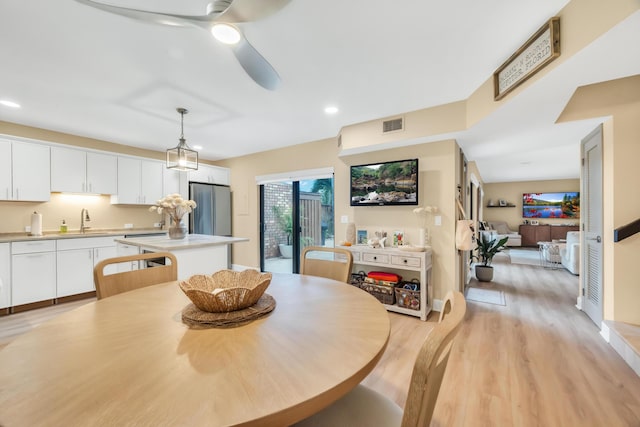 dining area featuring ceiling fan, sink, and light hardwood / wood-style flooring