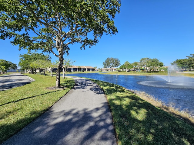 view of property's community with a yard and a water view