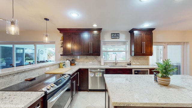 kitchen featuring light stone counters, sink, and stainless steel appliances