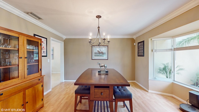 dining area with crown molding, plenty of natural light, an inviting chandelier, and light wood-type flooring