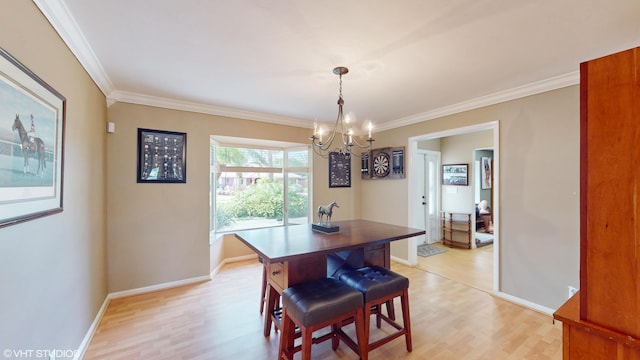 dining area with light hardwood / wood-style floors, ornamental molding, and a chandelier