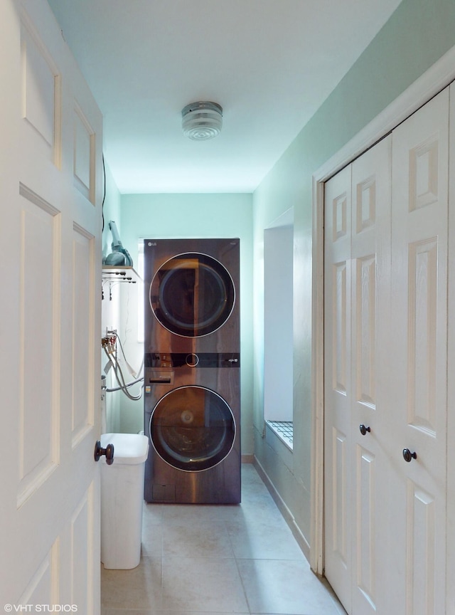 clothes washing area featuring stacked washer / dryer and light tile patterned floors