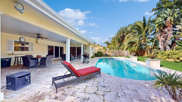 view of swimming pool featuring ceiling fan and a patio area