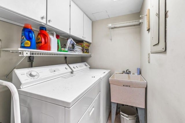 washroom featuring cabinets, separate washer and dryer, sink, and electric panel