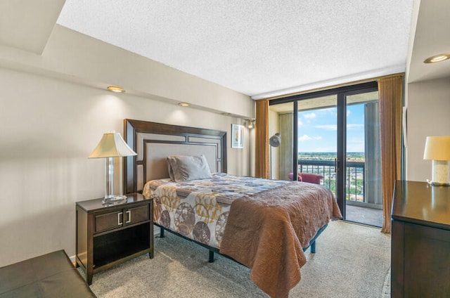 carpeted bedroom with access to exterior, a textured ceiling, and a wall of windows