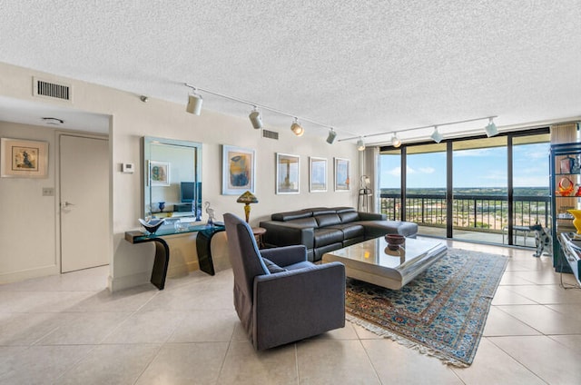 tiled living room with floor to ceiling windows, track lighting, and a textured ceiling