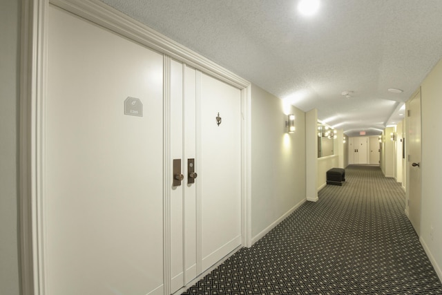 hallway with carpet and a textured ceiling