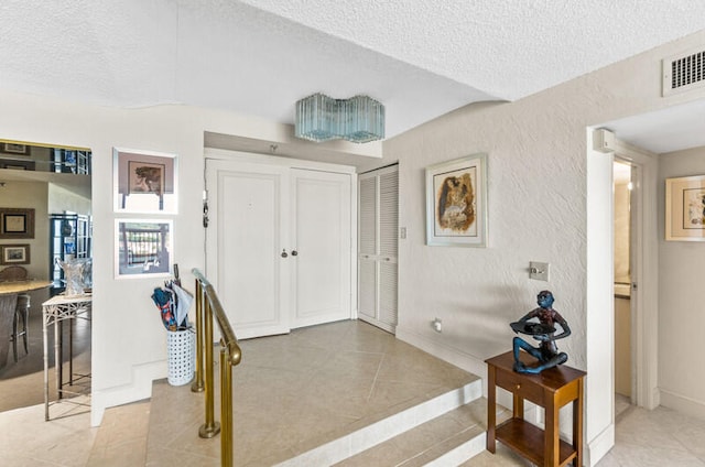 tiled foyer entrance with a textured ceiling