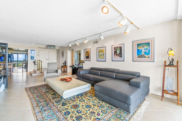 living room featuring rail lighting and light tile patterned flooring