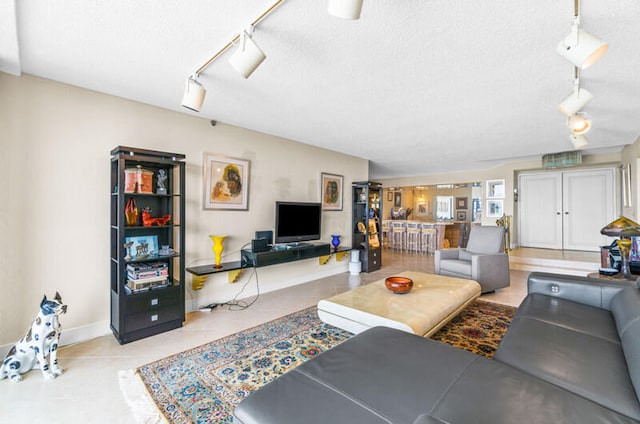 living room with a textured ceiling and track lighting