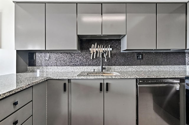 kitchen with dishwasher, backsplash, light stone counters, and sink