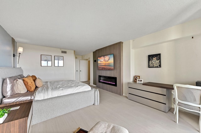 bedroom with a textured ceiling and a fireplace