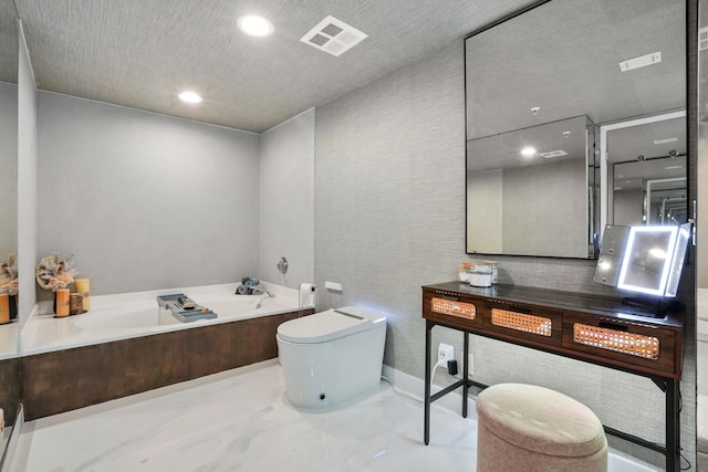 bathroom featuring vanity, toilet, and a tub to relax in