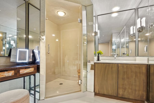 bathroom with vanity, toilet, and a shower with door