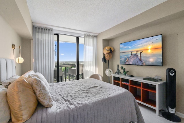 bedroom with access to outside, expansive windows, and a textured ceiling