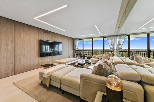 living room featuring floor to ceiling windows, plenty of natural light, and hardwood / wood-style floors