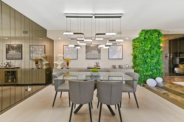 dining room with light hardwood / wood-style flooring and wood walls