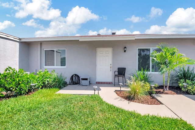 entrance to property with a yard and a patio